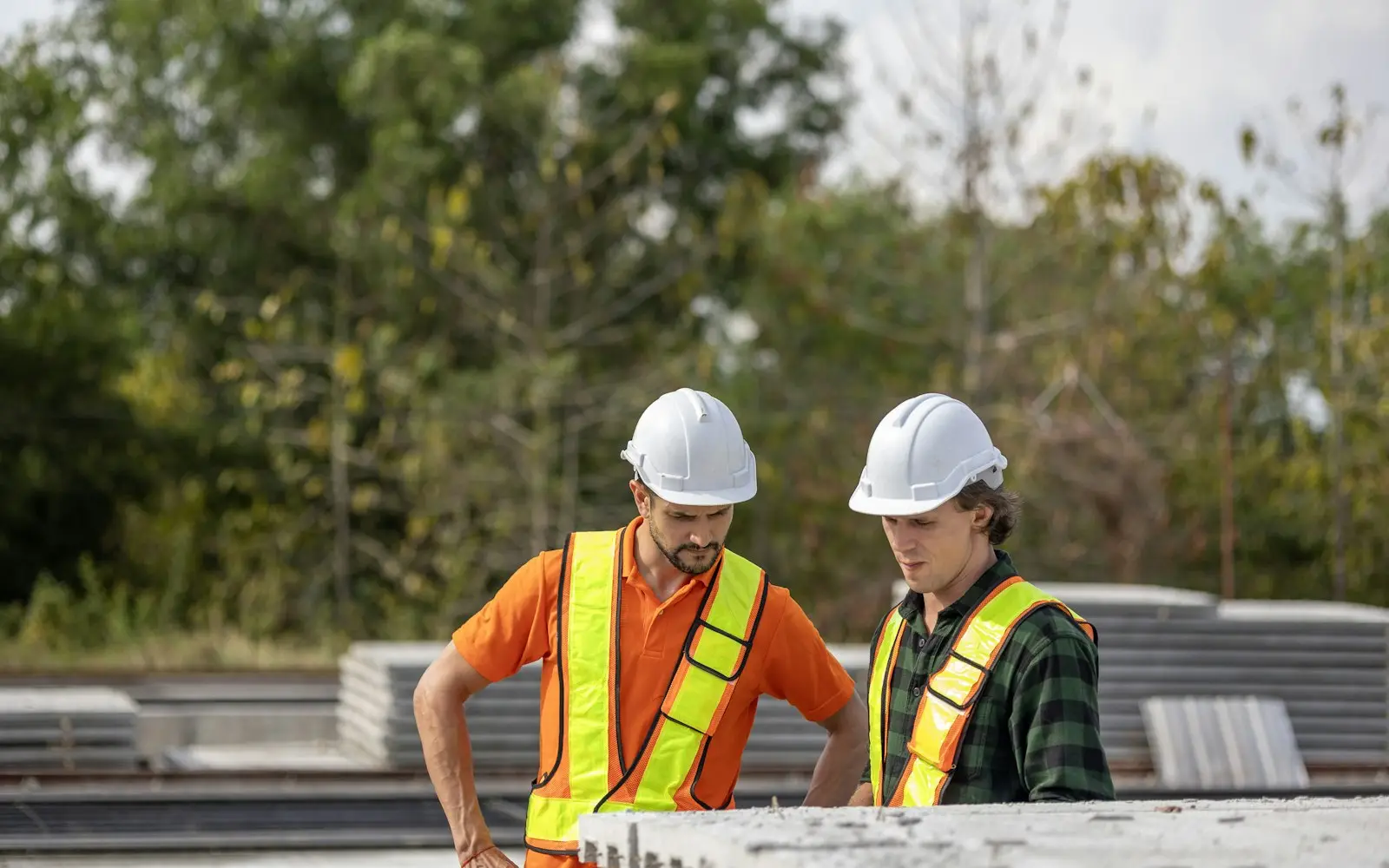Bauleute mit Helm besprechen Pläne auf der Baustelle
