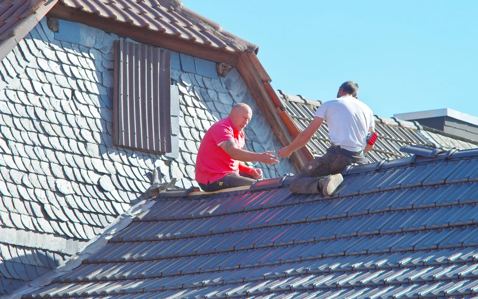 Zwei Dachdecker arbeiten auf dem Dach eines Hauses