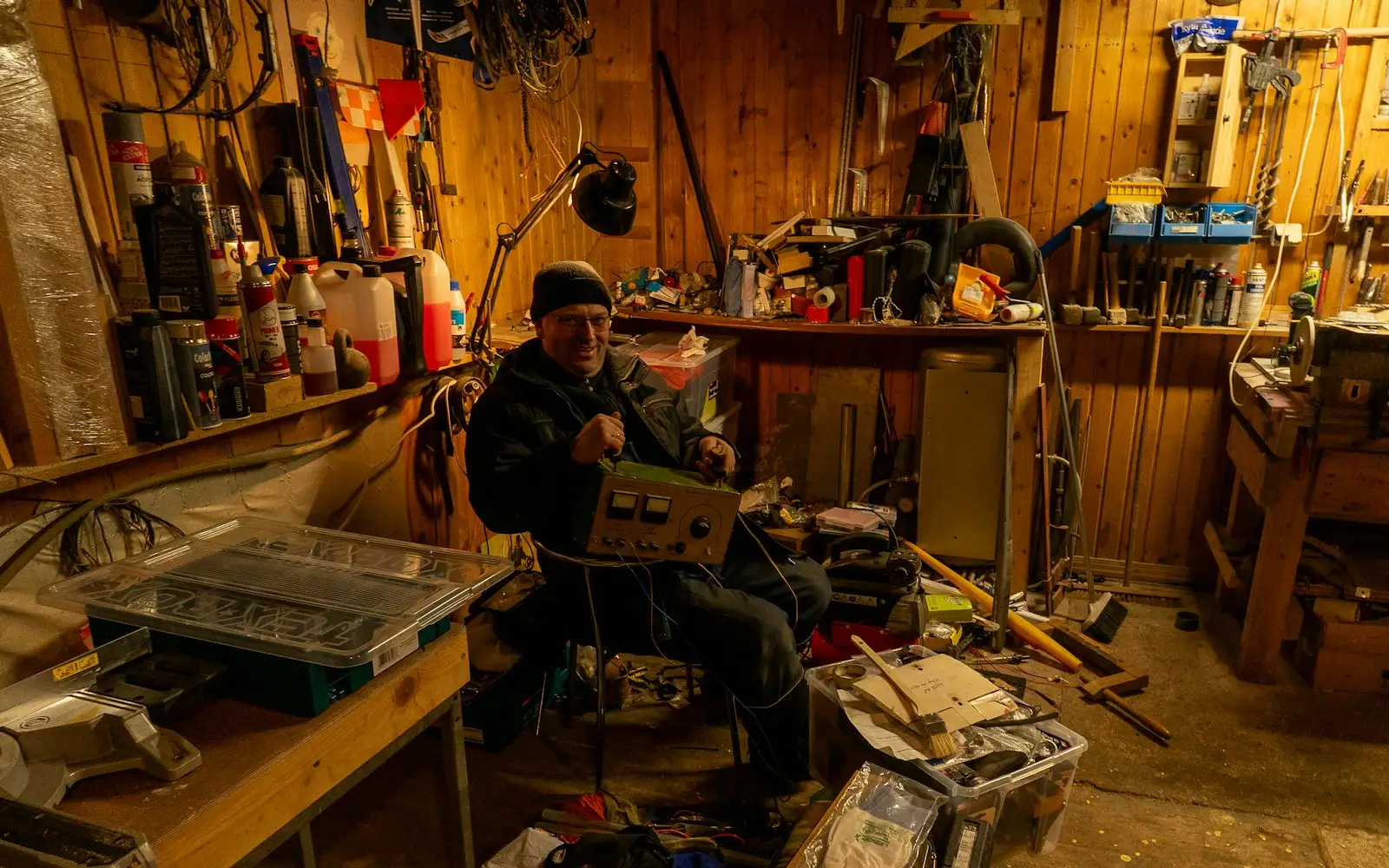 Handwerker sitzt in seiner Werkstatt am Laptop